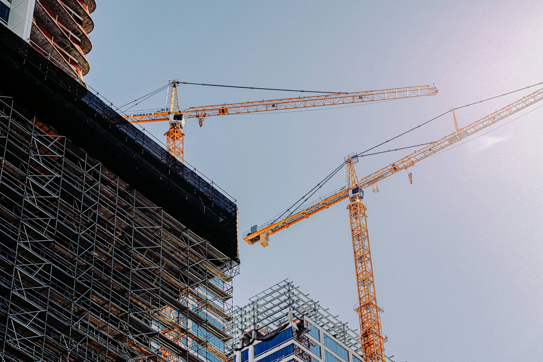 Construction cranes against blue sky